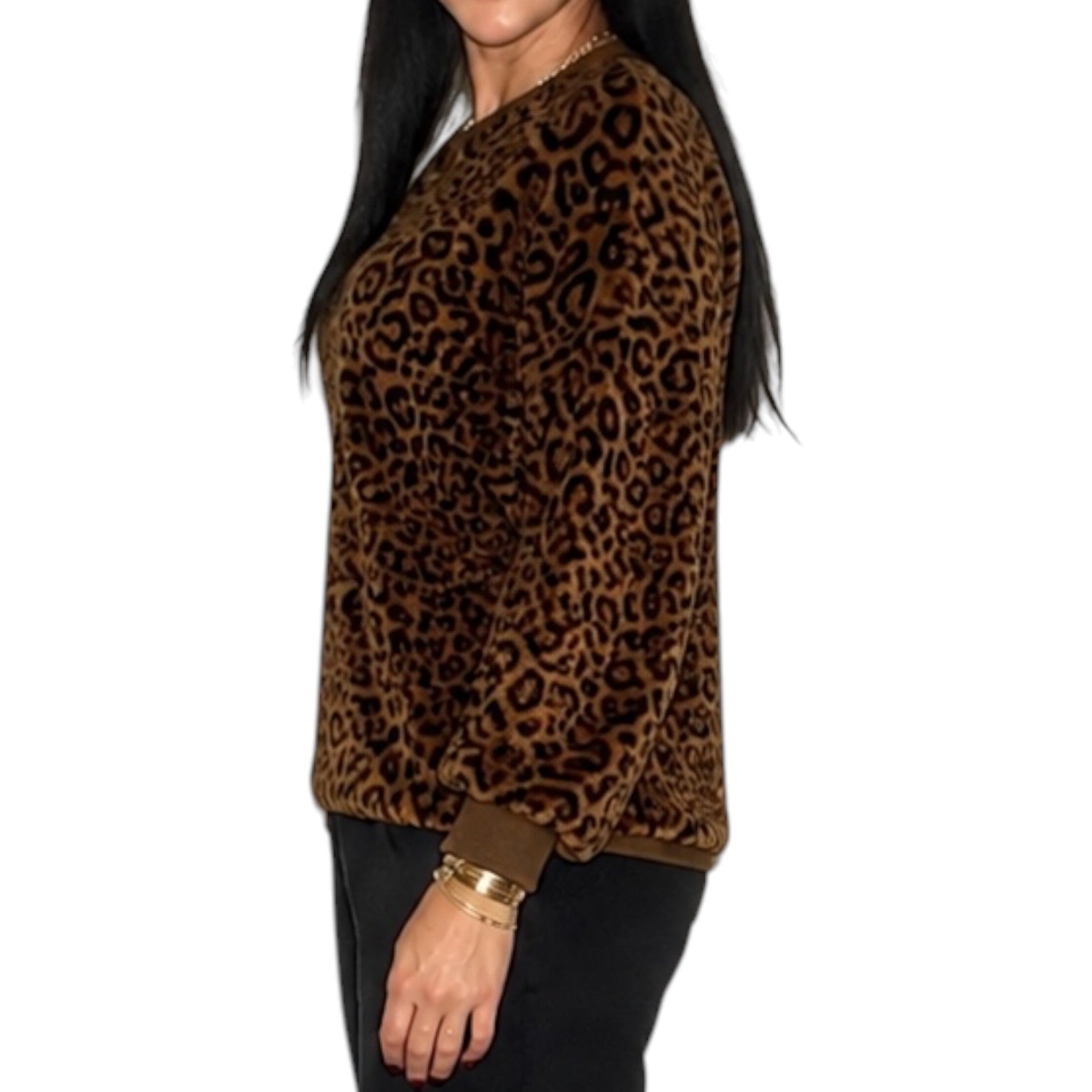 A woman wearing a brown and black leopard print long-sleeve top, shown from the side against a plain white background.