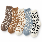 Five pairs of fuzzy ankle socks arranged in a fan shape on a white background, each with a contrasting leopard-like spot pattern in brown, tan, cream, light blue, and black.