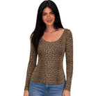 A woman modeling a long-sleeve scoop-neck top with a brown and black leopard print pattern, paired with blue jeans, against a plain white background.