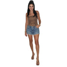 A woman modeling a leopard-print strapless camisole top and a denim mini skirt against a plain white background.