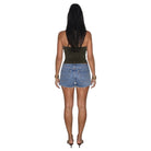 A woman shown from the back wearing a dark olive green textured strapless tube top and light blue denim cut-off shorts, paired with black high heels, against a plain white background.