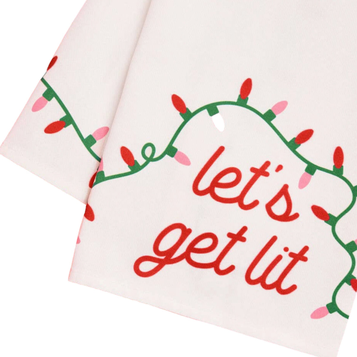 A close-up of a white fabric napkin or kitchen towel featuring a festive Christmas light design with the phrase 'let's get lit' in red script.
