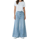 woman wearing light denim polka dot wide leg pants on white background