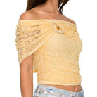 Yellow lace top worn by a person on a white background