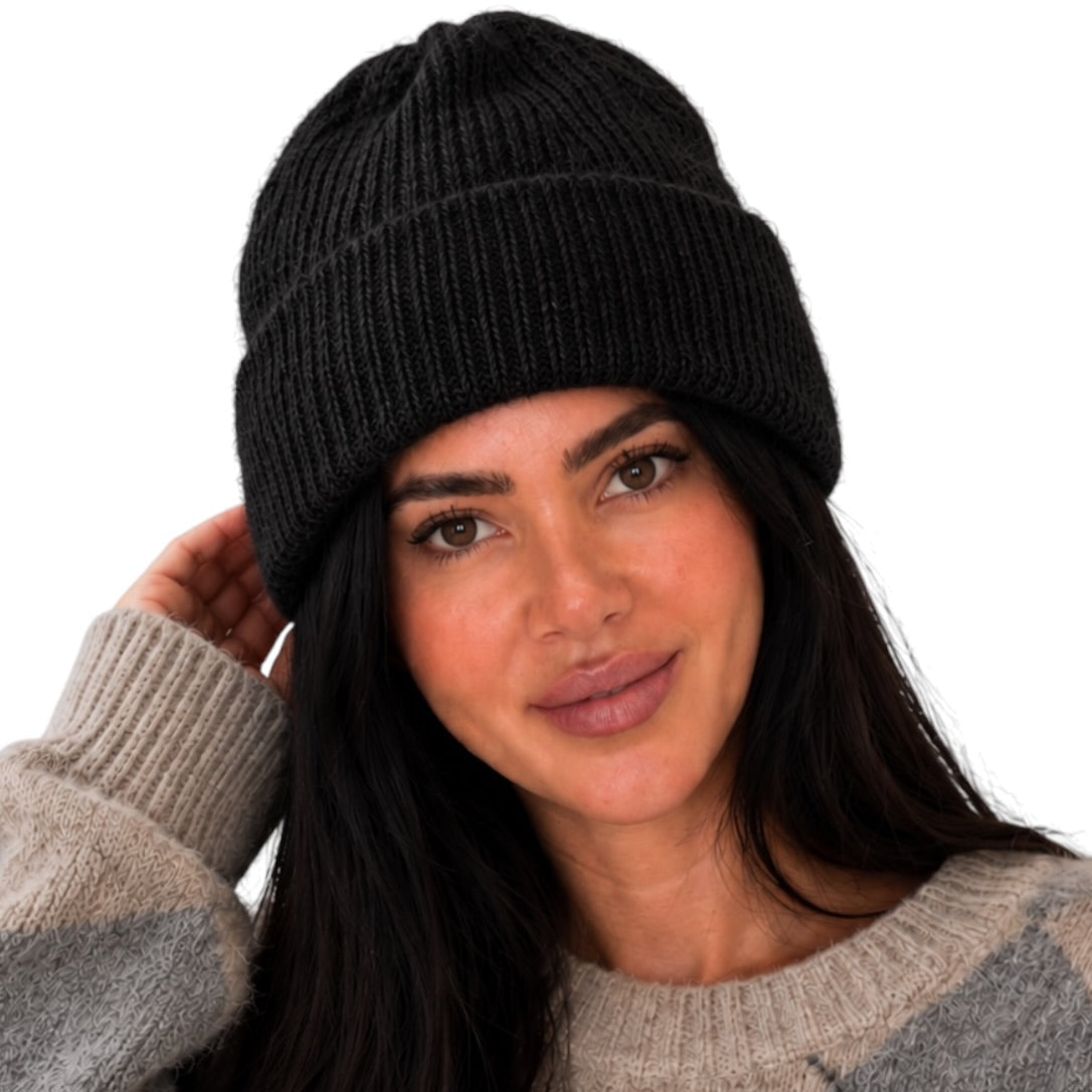A woman wearing a black ribbed knit beanie and a gray argyle sweater, shown against a plain white background.