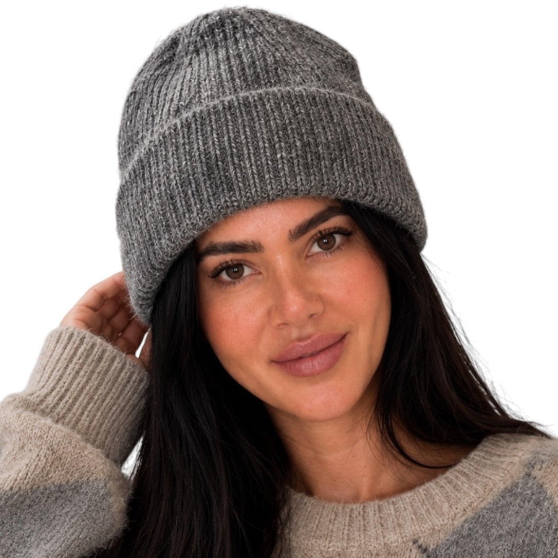A woman wearing a gray ribbed knit beanie and a beige and gray argyle sweater, shown against a plain white background.