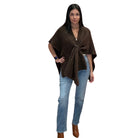 Woman wearing a brown poncho and blue jeans