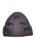 brown knit beanie with black bows on a white background