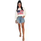 a woman wearing an american flag sweater on a white background