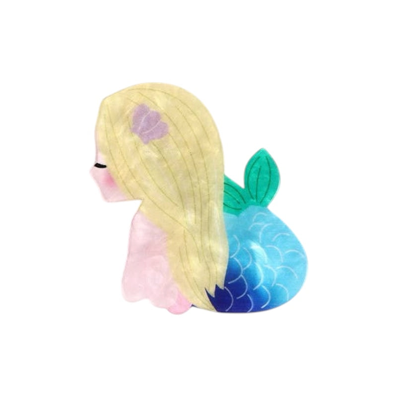 Mermaid-shaped squishy toy with blonde hair and a blue tail on a white background