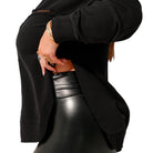 Person wearing a black jacket and black leather pants on a white background