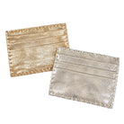 Two slim card holders with a textured metallic finish, one in gold and one in silver, displayed on a clean white background.