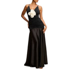 Black evening gown with a white floral accent on a white background
