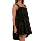 Black tiered dress worn by a model on a white background