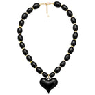 Necklace with black heart pendant and gold accents on a white background