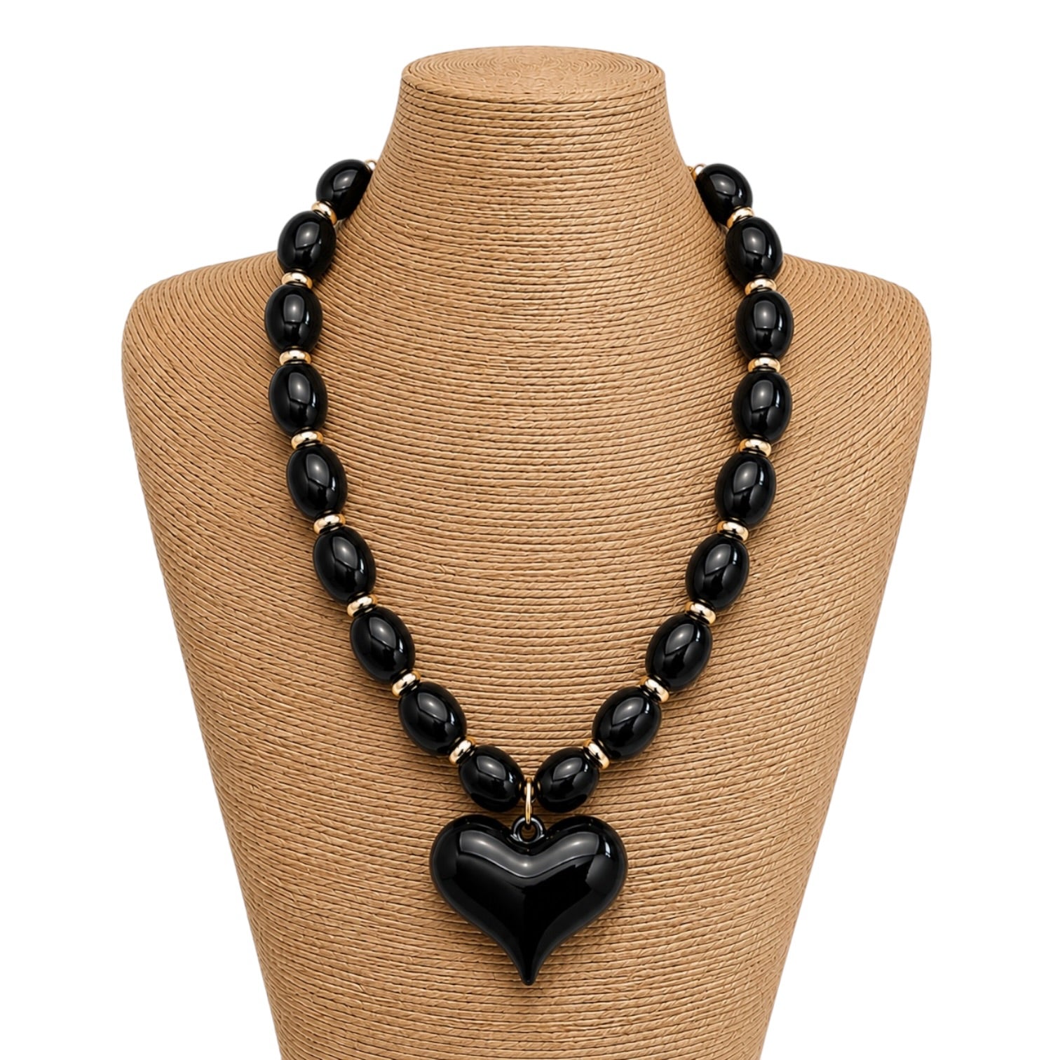 Black beaded necklace with a heart pendant on a mannequin bust.