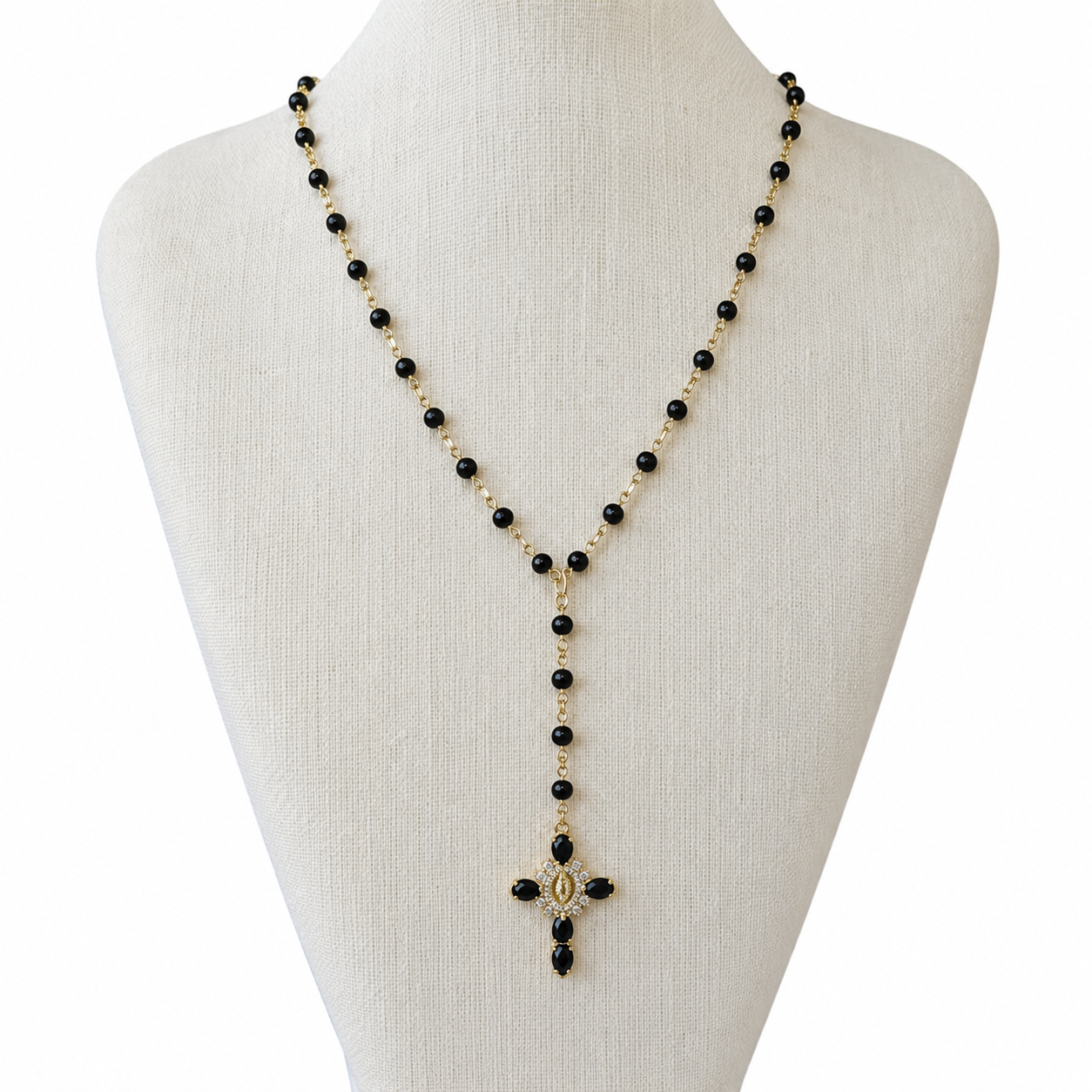 A black and gold beaded lariat-style necklace displayed on a cream fabric mannequin bust against a white background.