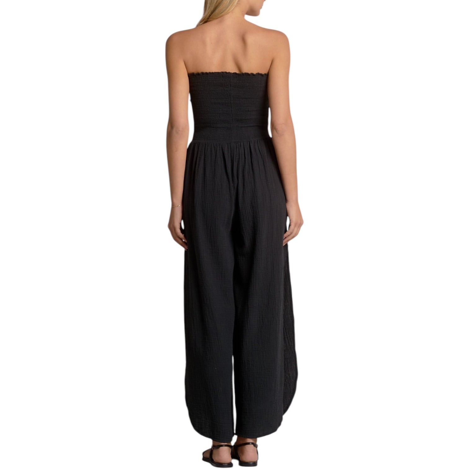 Black strapless jumpsuit worn by a model on a white background