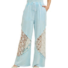 Light blue pants with lace detailing on a white background