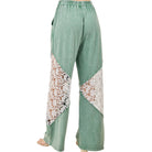 Green pants with lace panels on a white background
