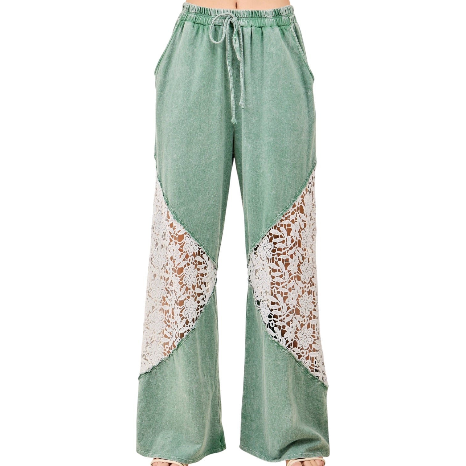 Green pants with lace detailing on a white background
