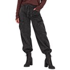 A person wearing dark charcoal cargo jogger pants with an elastic drawstring waist, side cargo pockets, and elastic cuffs, paired with black lace-up ankle boots against a plain white background.