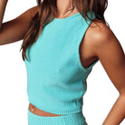 Person wearing a turquoise sleeveless top on a white background