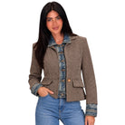 A woman modeling a cropped houndstooth blazer with denim collar, cuffs, and button placket, paired with blue jeans against a plain white background.