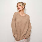 Woman wearing a mocha sweater against a white background