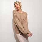 Woman wearing a mocha sweater against a white background