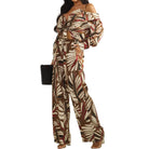 a woman wearing a palm printed two piece pant set on white background
