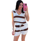 Woman taking a selfie wearing a brown and white striped outfit on a white background