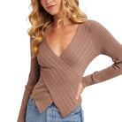 Woman wearing a brown ribbed sweater with a white background