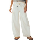 Person wearing white wide-leg pants on a white background