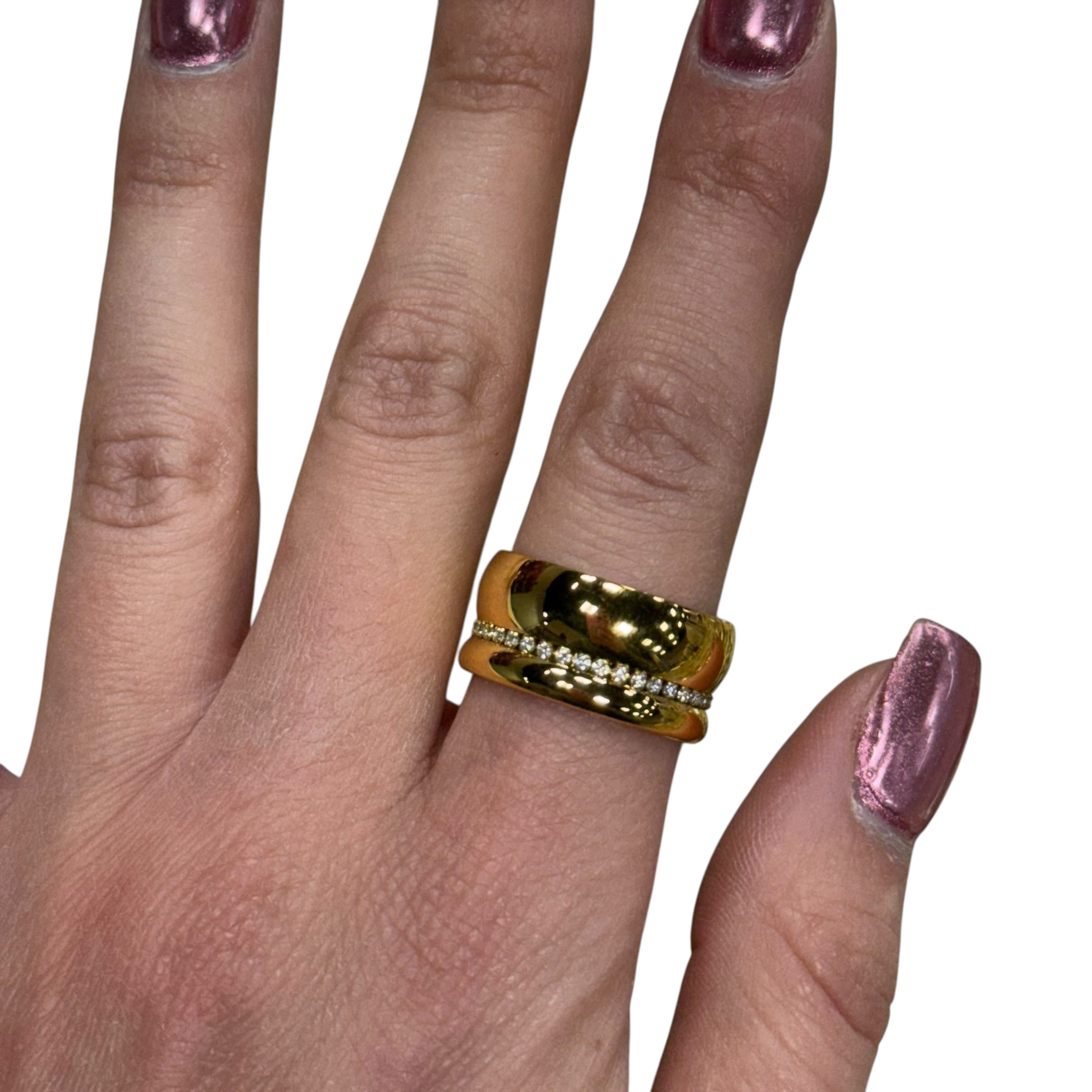 Gold ring on a finger with pink nail polish against a white background