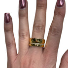 Gold ring on a finger with a white background