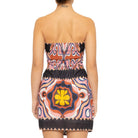 Woman wearing a strapless dress with a colorful geometric pattern on a white background