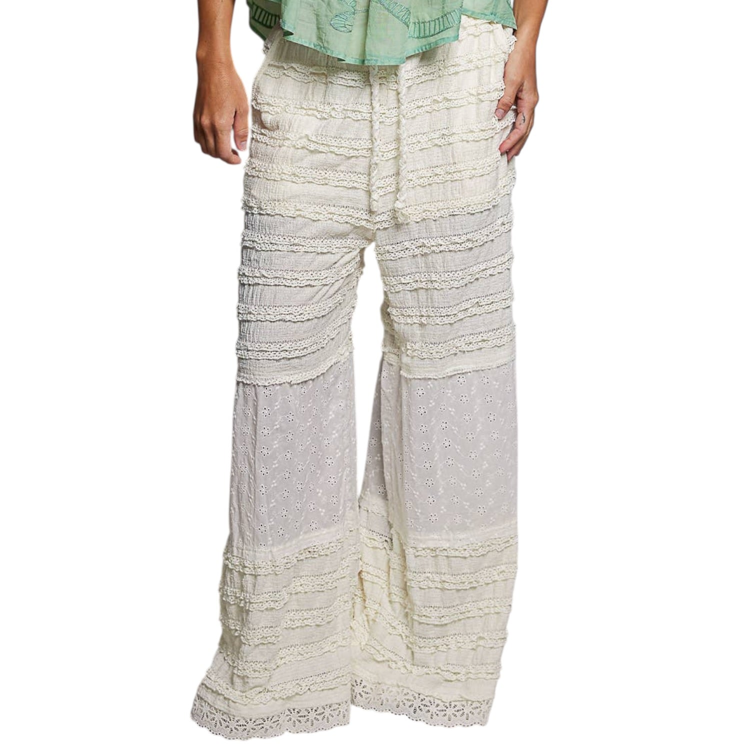 White lace pants worn by a person on a white background