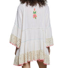 White dress with floral embroidery and lace details on a white background