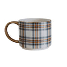 A white ceramic mug with a brown and navy blue plaid pattern and a metallic gold handle, shown on a plain white background.