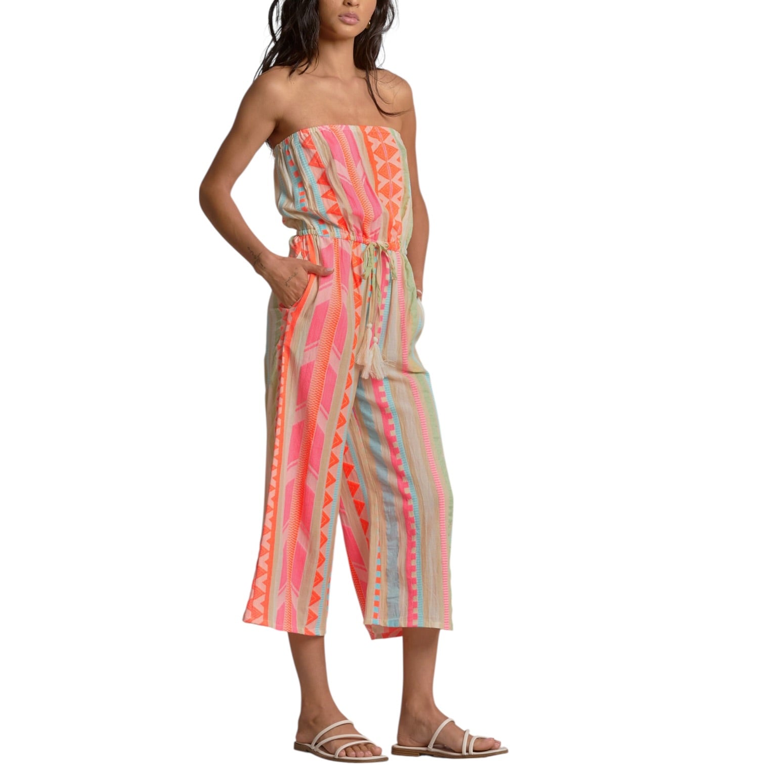 Woman wearing a strapless, multicolored jumpsuit on a white background