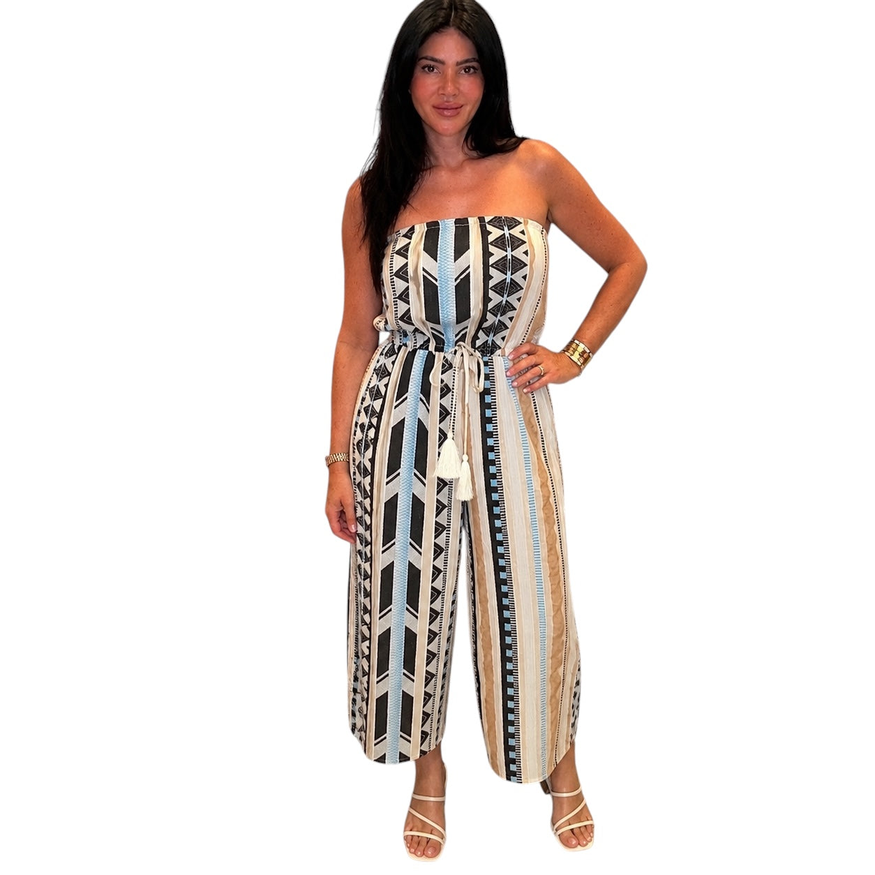 Woman wearing a strapless, patterned jumpsuit on a white background