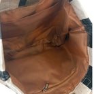 Brown bag with a zipper on a checkered fabric background