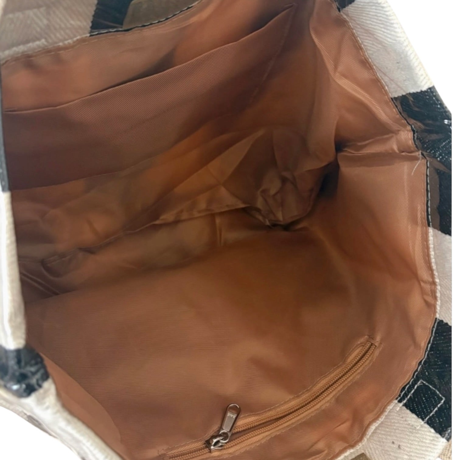 Brown bag with a zipper on a checkered fabric background