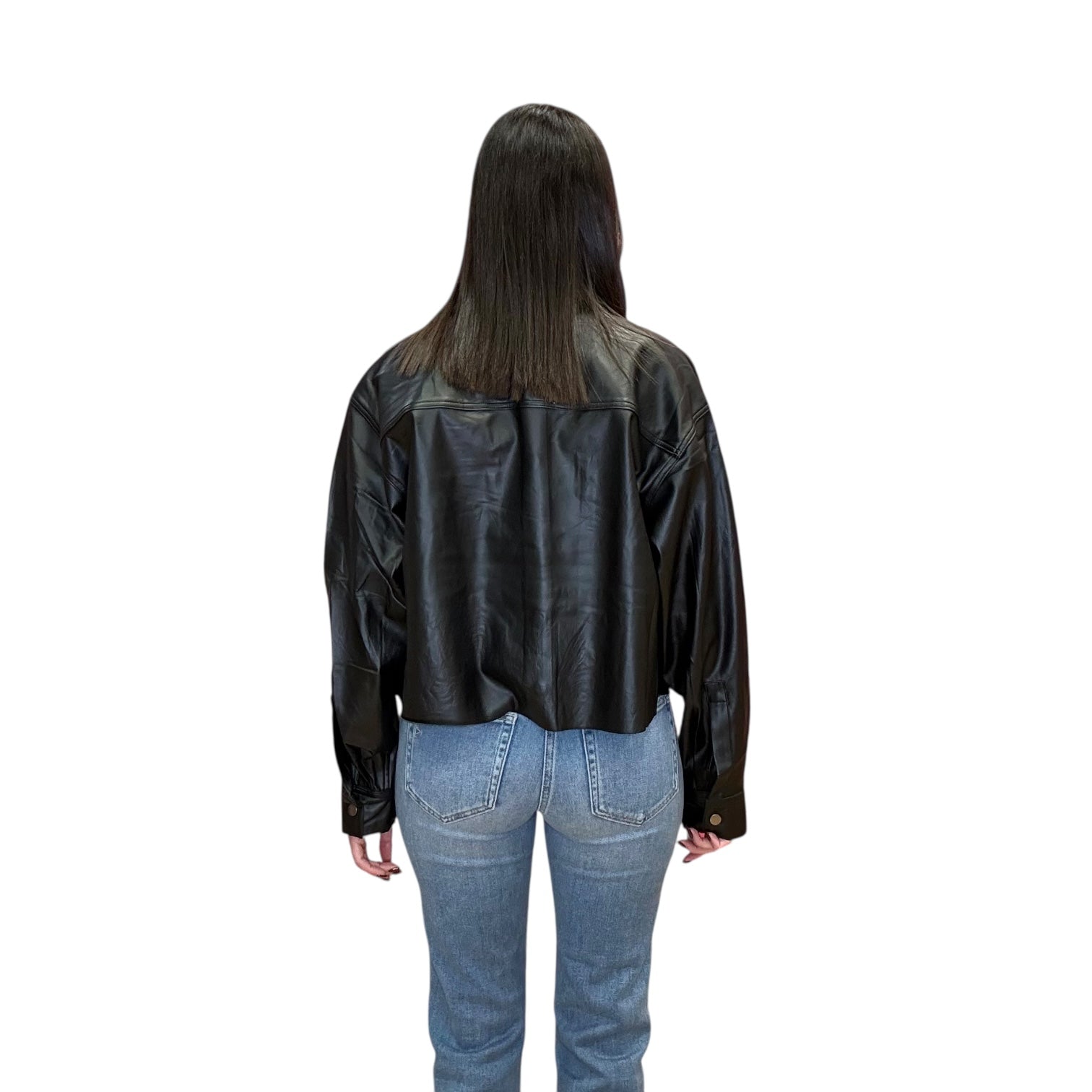 Person wearing a black leather jacket and blue jeans on a white background