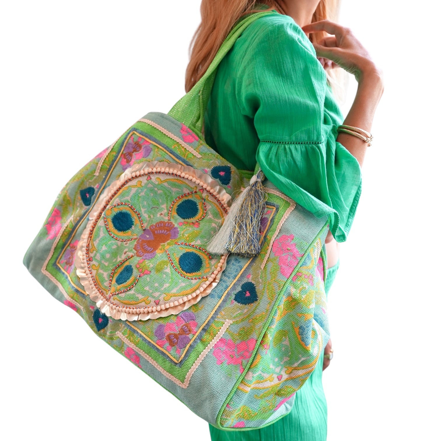 Woman holding a colorful embroidered bag with a white background