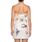 Woman wearing a strapless dress with sea-themed sequin pattern on a white background