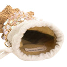 Close-up of a decorative bag with textured surface and visible brand name on a white background