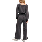 Person wearing a gray jumpsuit on a white background