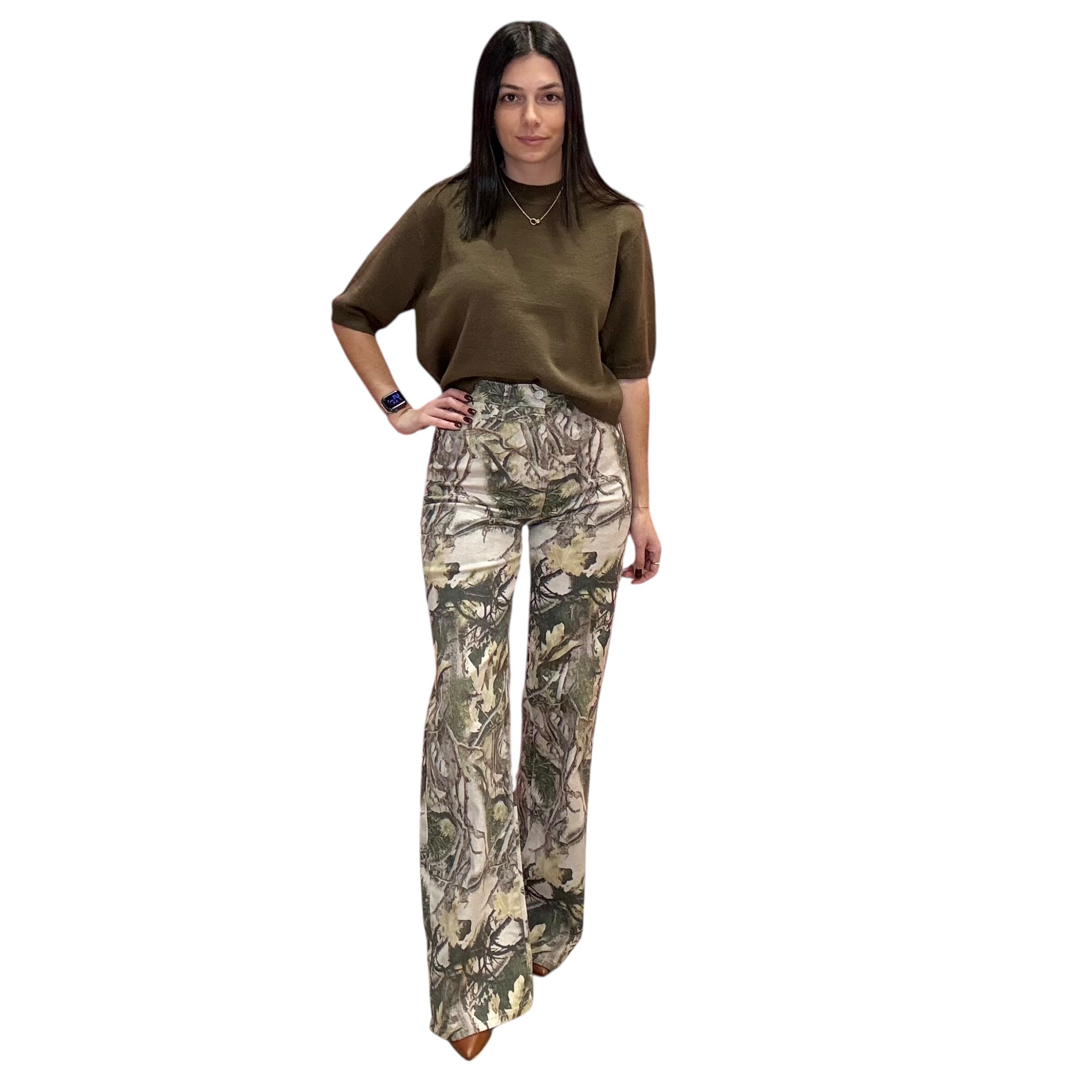 Woman wearing a olive top and camouflage pants on a white background